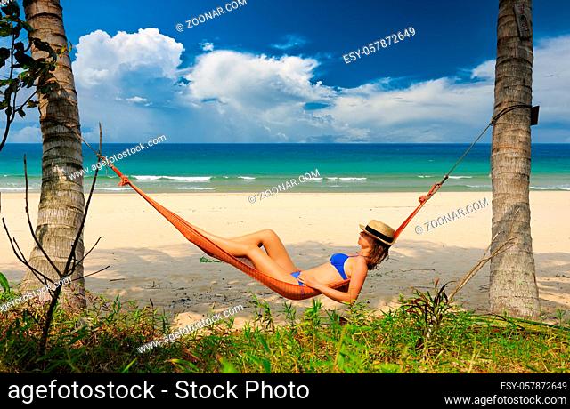 Woman in hammock on tropical beach at Tioman island, Malaysia
