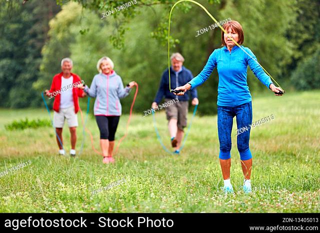 Gruppe Senioren beim Seilspringen in einem Ausdauer Fitness Kurs im Park