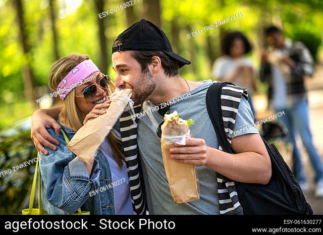 Weekend. Young people eating sandwiches and having fun