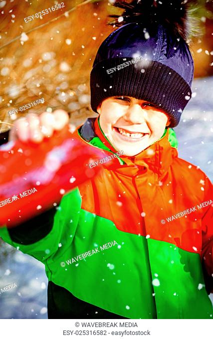 Composite image of portrait of cute boy giving present