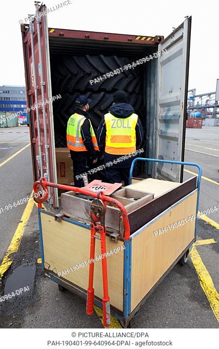 21 March 2019, Hamburg: Customs officers at the Hamburg customs office check the contents of a container at a container terminal in the port of Hamburg
