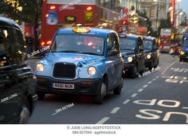 Taxi Cabs, double decker buses and cars on Oxford Street, London, England, at twilight