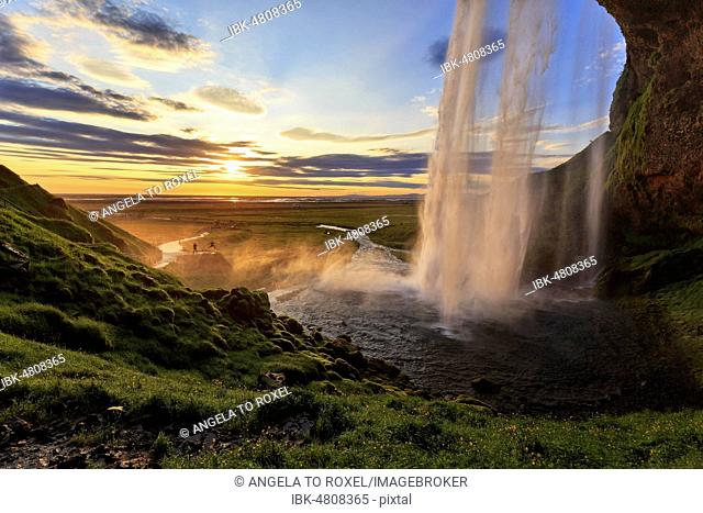 Seljalandsfoss at sunset, next to two people, silhouettes at the photo shoot, Suðurland, Sudurland, near ring road, South Iceland, Iceland