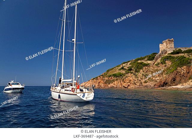 Boat anchored by a Genoese Tower, village of Girolata, Corsica, France