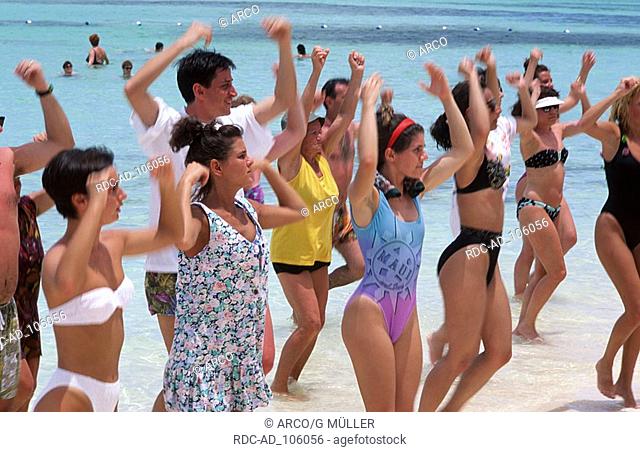 Vacationists doing sports at beach Punta Cana Dominican Republic Urlauber beim Fitnesstraining am Strand Punta Cana Dominikanische Republik