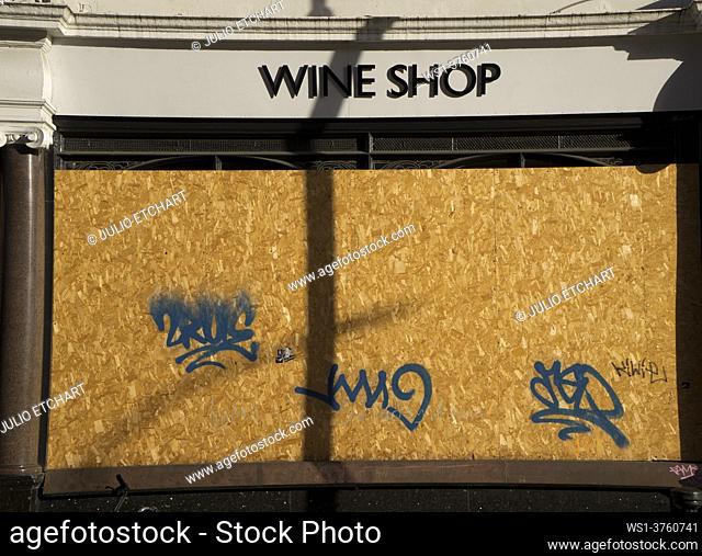 Boarded up wine shop closed due to lockdown Covid-19/Coronavirus pandemia restrictions in London, England, UK
