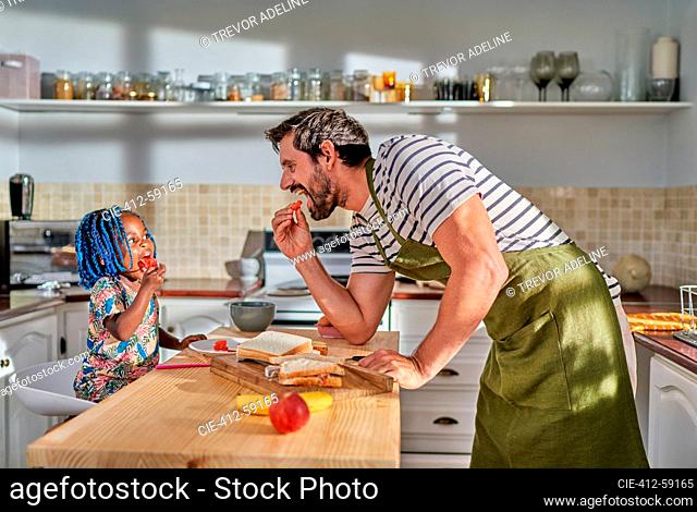 Father and daughter eating at kitchen island