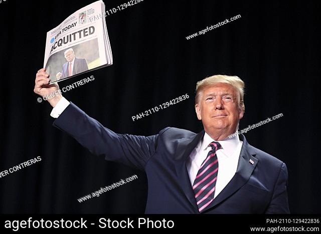 United States President Donald J. Trump holds a newspaper as he arrives to the 68th Annual National Prayer Breakfast at the Washington Hilton on February 6