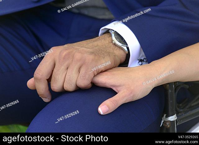 The bride and groom hold hands at the wedding ceremony