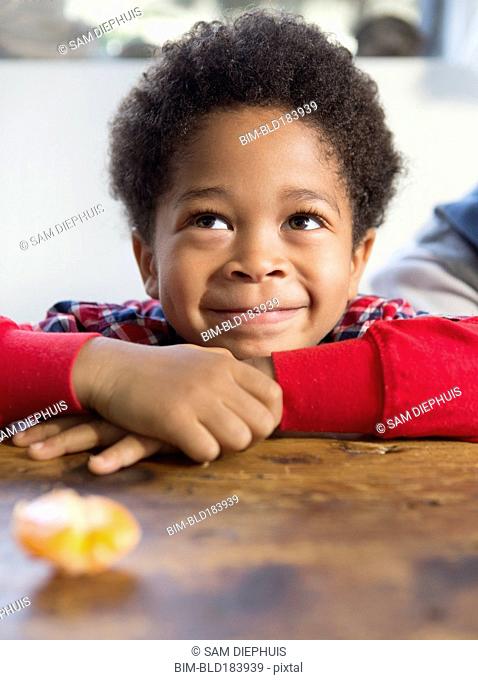 Mixed race boy smiling at table
