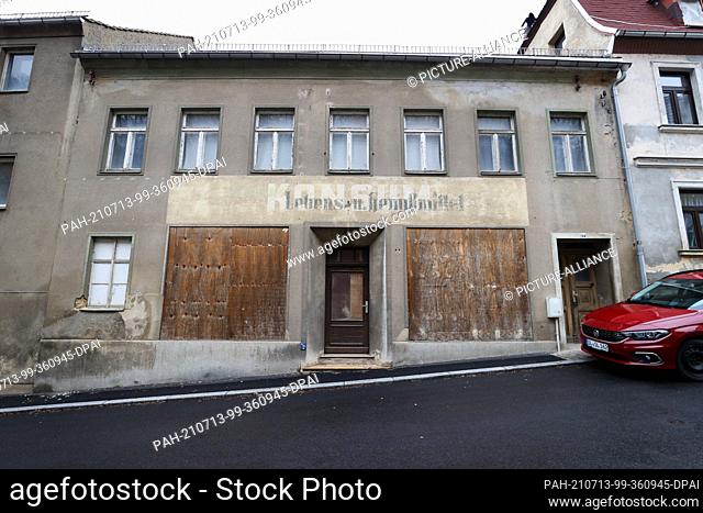 02 February 2021, Saxony, Leisnig: The faded inscription points to a former ""Konsum"" with ""Lebens- u. Genußmittel"". On the street ""Schloßberg"" there are...