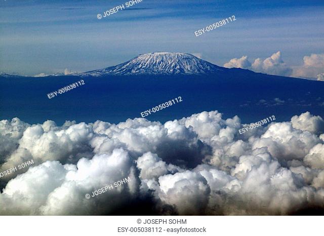 Aerial image of Mount Kilimanjaro, Africas highest mountain, with snow and white puffy clouds from Kenya