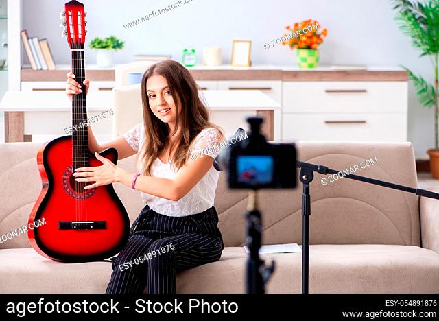 Female beautiful blogger playing guitar