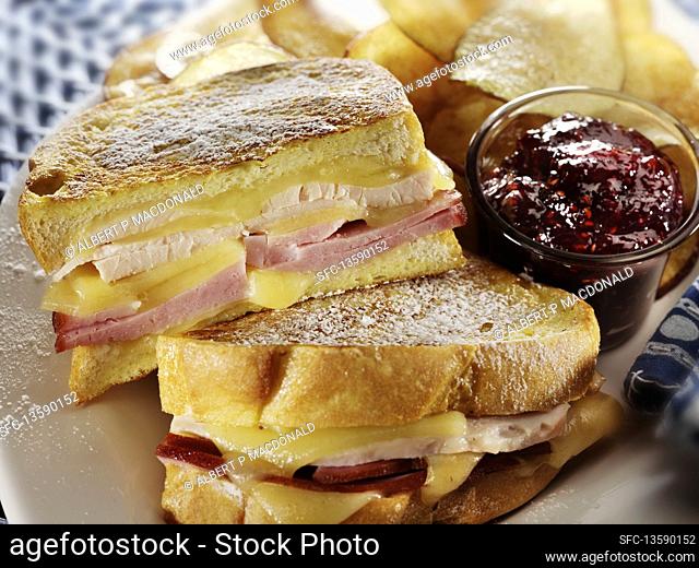 Monte Cristo sandwich with tureky ham, cheese, raspberry jam and potato chips on the side