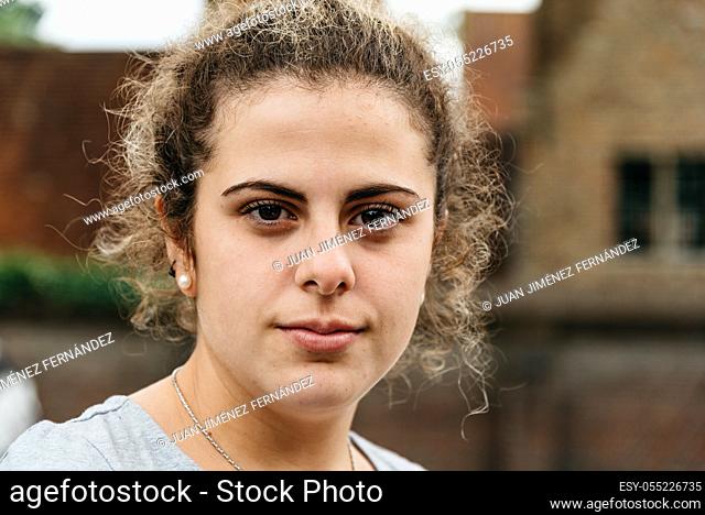 Headshot of young adult woman in the street with space for copy