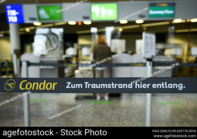 15 June 2020, International, Frankfurt/Main: A woman, who has a residence on Tenerife, checks in at Terminal 1 of Frankfurt Airport for a Condor flight to...
