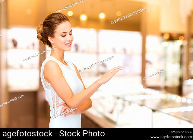 smiling woman with diamond ring at jewelry store