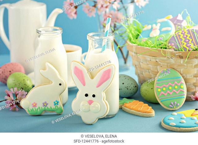 Easter cookies on blue table with milk in little bottles