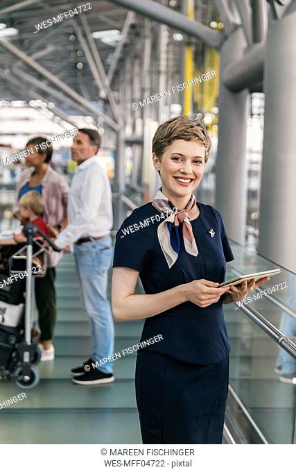 Portrait of smiling airline employee holding tablet at the airport