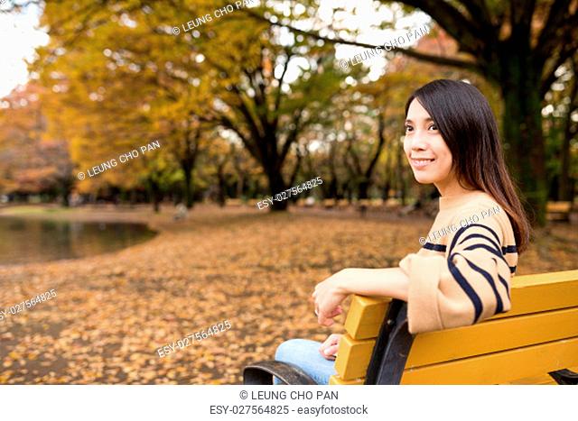 Woman looking far away and sitting at park
