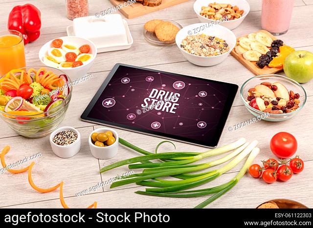 DRUG STORE concept in tablet pc with healthy food around, top view