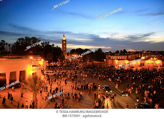 Koutoubia Mosque illuminated with red light, Djemaa el-Fna Square of the Hanged Man in the medina quarter of Marrakech at dusk with its countless food stalls