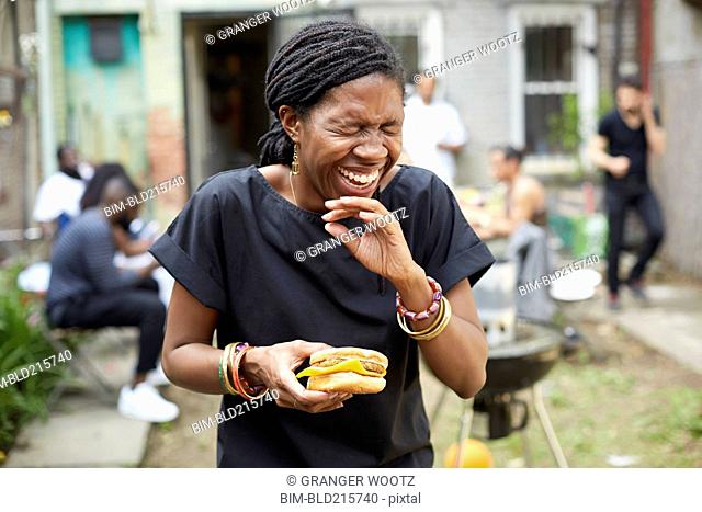 African American woman eating at backyard barbecue