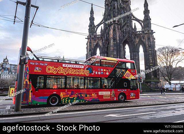CitySightseeing Hop-On Hop-Off bus in front of Scott Monumen to Scottish author Sir Walter Scott in Edinburgh, the capital of Scotland, part of UK