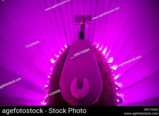 Illuminated empty spa treatment room with purple lights