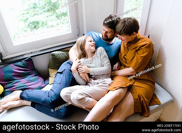 Father and mother talking to daughter at home