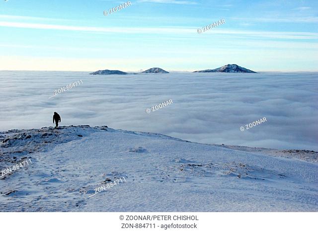 Hillwalker ascending Ben Challum with cloud inversion behind