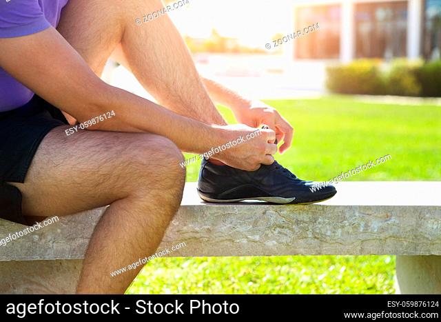 Athlete man trying running shoes getting ready for jogging in the park
