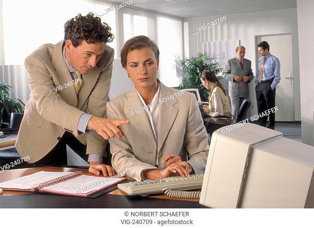 portrait, office-scene, man, ca. 40 years, is talking about a project with his colleague sitting at the computer  - 0, GERMANY, 08/10/2002