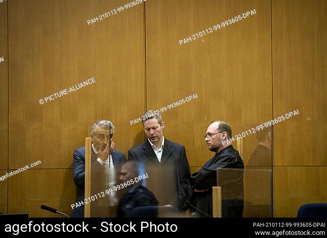12 January 2021, Hessen, Frankfurt/Main: The main defendant Stephan Ernst (M) speaks with his lawyers Mustafa Kaplan (l) and Jörg Hardies in a courtroom of the...
