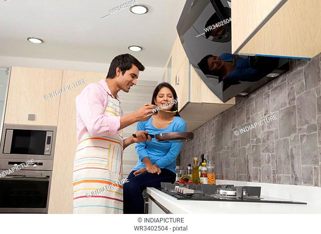 Smiling couple preparing food in kitchen