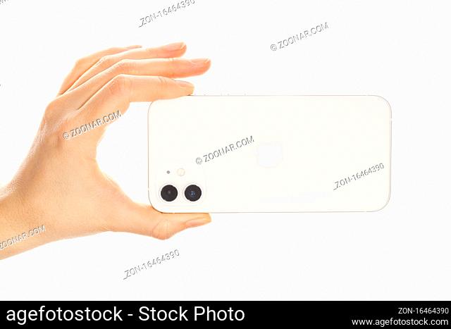 Bratislava, Slovakia - December 07, 2020. Female hand holding the new iPhone 12 White