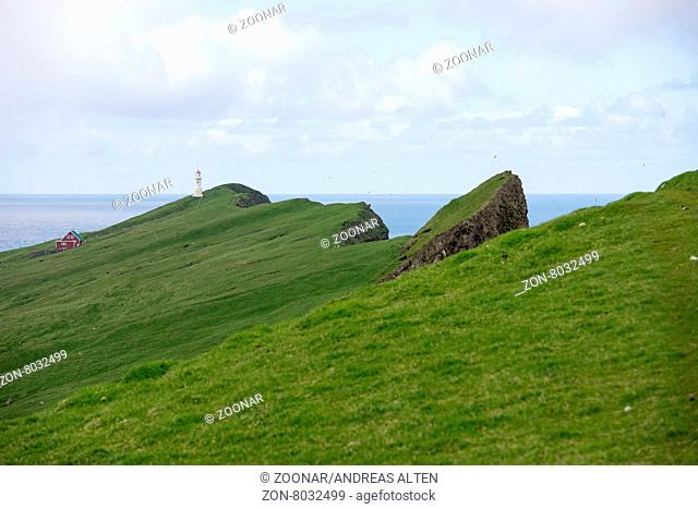 Mykines-Holmur auf den Färöer Inseln mit grünem Gras und Klippen / Mykines-Holmur on the Faroe Islands, with green grass, cliffs, and rocks