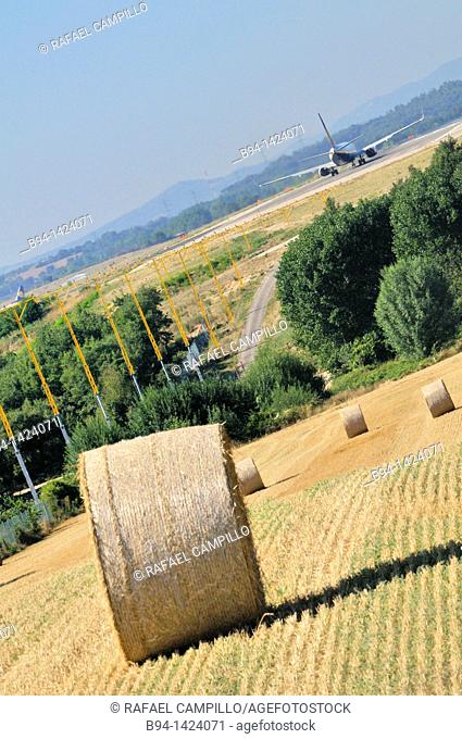 Plane and straw rolls. Girona-Costa Brava Airport, at 12.5 km southwest of the city of Girona, next to the small village of Vilobí d'Onyar. Girona