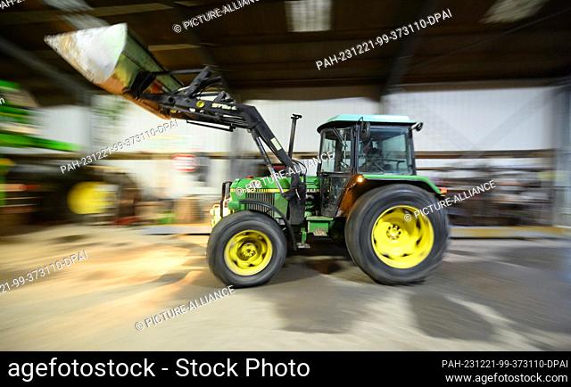 21 December 2023, Lower Saxony, Hanover: A farmer in the Hanover region drives his wheel loader into a vehicle shed. Recently