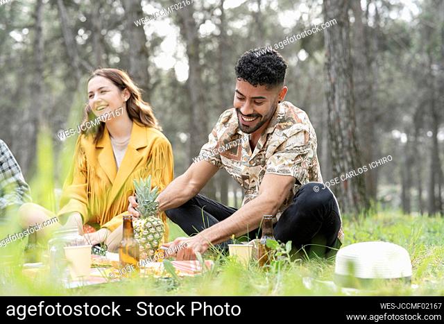 Male and female friends enjoying picnic at forest