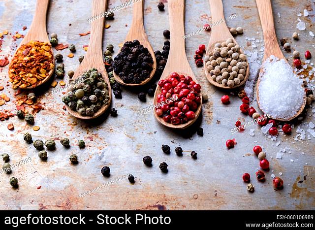 colorful spices in wooden spoons on steel plate