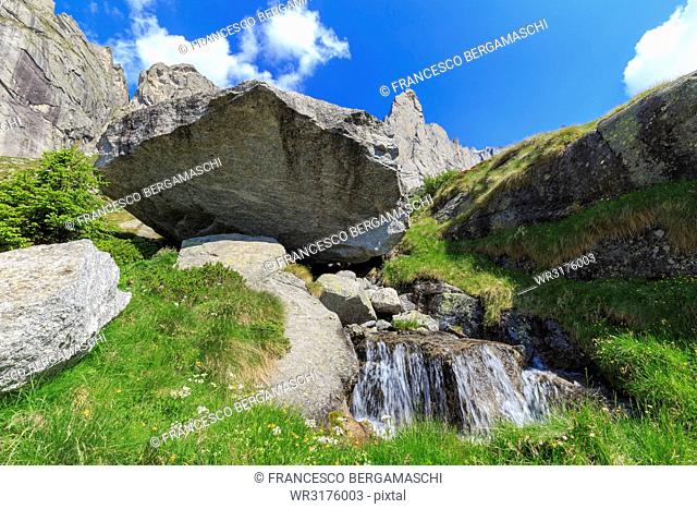 Balancing rock and torrent in Torrone Valley, Valmasino, Valtellina, Lombardy, Italy, Europe