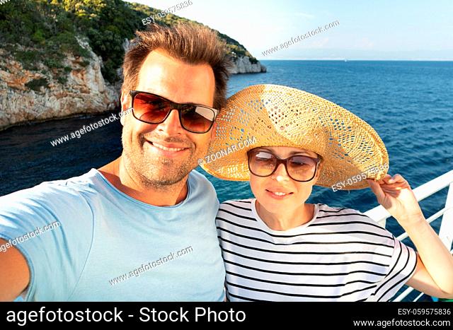 Beautiful, romantic caucasian couple taking selfie self portrait photo on summer vacations traveling by cruse ship ferry boat
