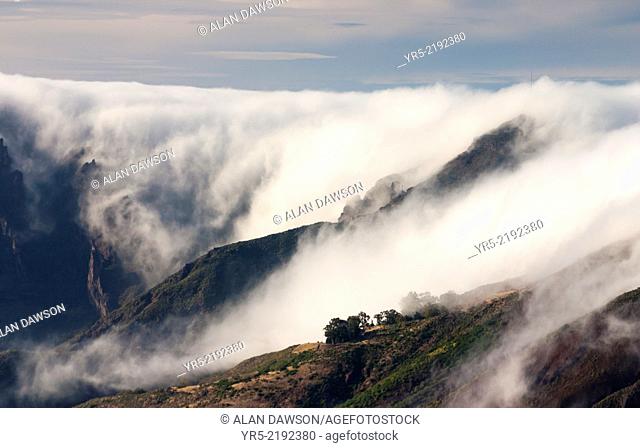View over central volcanic crater on Gran Canaria near Tejeda with Orographic cloud flowing over mountains. Canary Islands, Spain