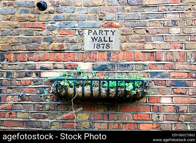 Old brick wall with planter and sick indicating Party Wall 1878. High quality photo