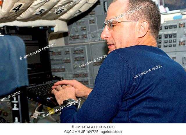 Astronaut Donald Pettit, STS-126 mission specialist, uses a computer on the flight deck of Space Shuttle Endeavour during post launch activities