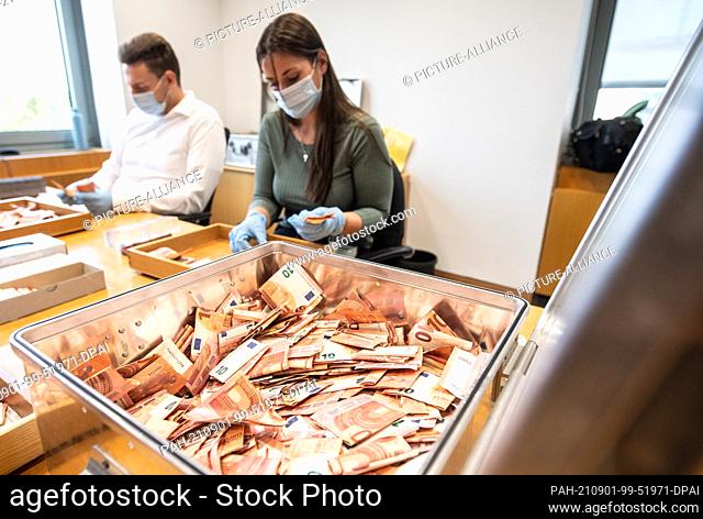01 September 2021, Mainz: Bundesbank employees at work on Wednesday, sorting through stacks of bank notes rescued from this summer's floods in Germany