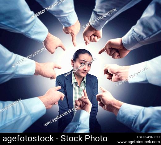 Shy businesswoman with men&#39;s fingrers pointed at her