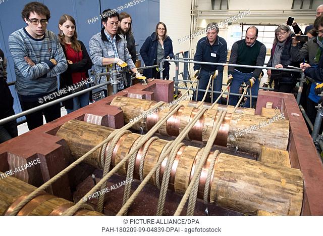 Uwe Dorka (6-L), line manager of steel and composite construction at the University of Kassel, and visitors standing around a true to the original 1-1 replica...