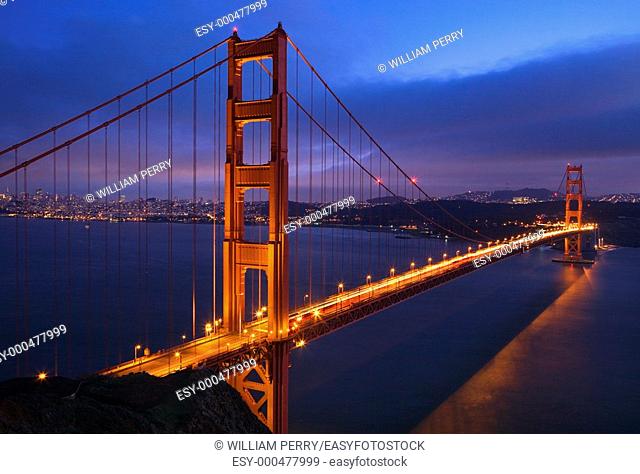 Golden Gate Bridge Sunset Pink Skies Evening with Lights of San Francisco California in background
